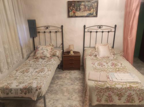 a bedroom with two twin beds and a night stand at Casa Solana in Cambil