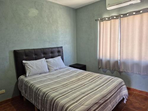 a bedroom with a large bed with a window at Bugambilias Condo D with Pool and Beach Access - Rancho Bugambilias in San Felipe