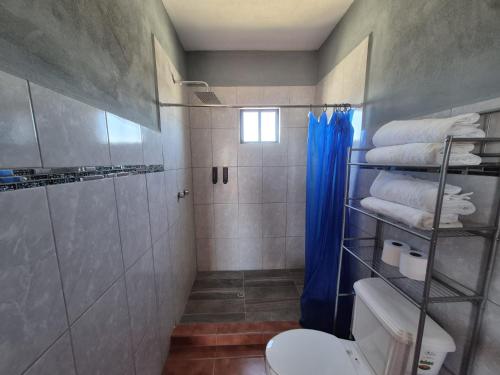 a bathroom with a shower and a toilet and towels at Bugambilias Condo D with Pool and Beach Access - Rancho Bugambilias in San Felipe