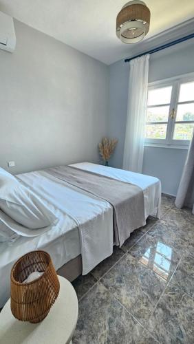 a bedroom with a large bed and a window at Κάρτ Ποστάλ Τρίκερι- Carte Postale Trikeri in Trikeri