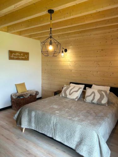 a bedroom with a bed and a wooden wall at Gîte Chalet Bellevue in Couvin
