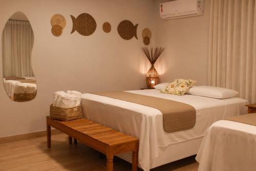 a bedroom with a bed and a bench in a room at Pousada Encantos de Arraial in Arraial d'Ajuda