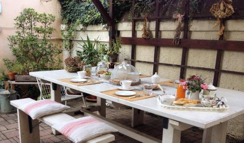 una mesa blanca con comida en el patio en B&B La Magnolia, en Ostiglia