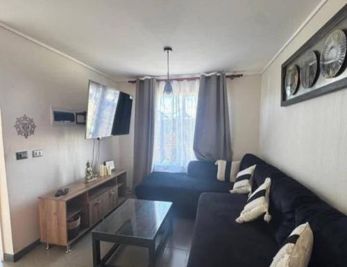a living room with a black couch and a table at Hipolito in La Serena