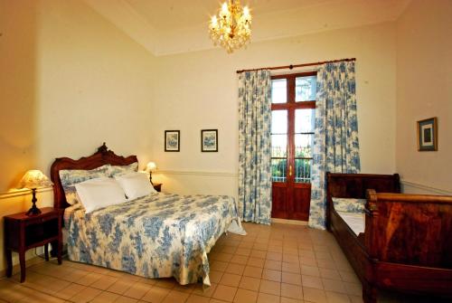 a bedroom with a bed and a window and a chandelier at Domaine Saint Ferreol in Nizas