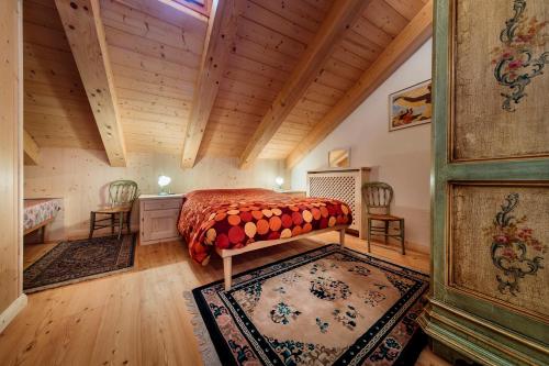 1 dormitorio con cama y techo de madera en Villa Olimpia - Stayincortina, en Cortina dʼAmpezzo
