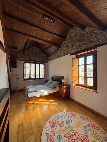 a bedroom with a bed and two windows at Casa Chita in Tapia de Casariego