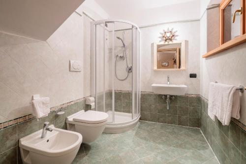 y baño con aseo, ducha y lavamanos. en Villa Olimpia - Stayincortina, en Cortina dʼAmpezzo