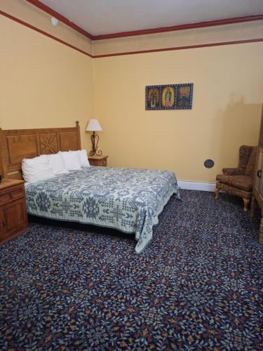 a bedroom with a bed and a chair at Historic Plaza Hotel in Las Vegas