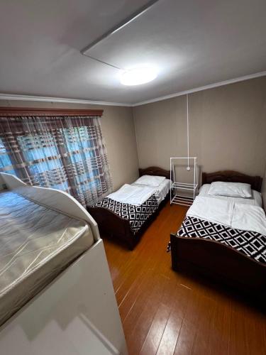 a bedroom with two beds and a window at Sweet Home 3 in Sevan