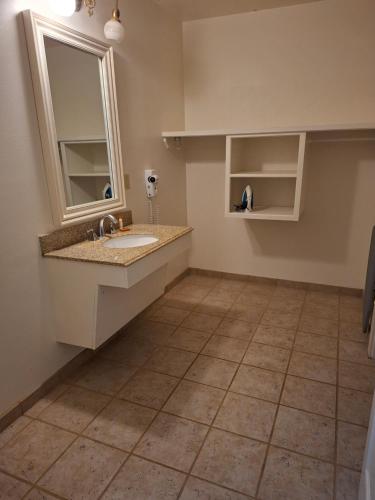 a bathroom with a sink and a mirror at Historic Plaza Hotel in Las Vegas