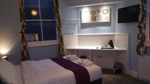 a bedroom with a bed with towels on it at Ali Inn Oxford in Oxford