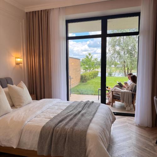 two people sitting in a room with a large window at Lakes Places Villas in Kyiv
