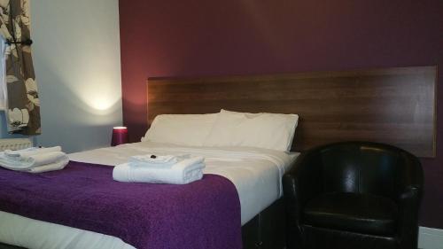 a hotel room with a bed with towels on it at Ali Inn Oxford in Oxford