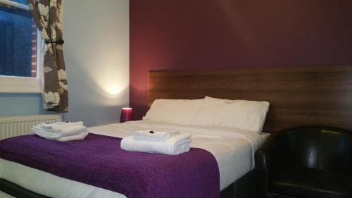 a hotel room with a bed with towels on it at Ali Inn Oxford in Oxford