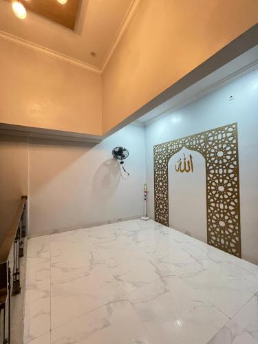 a room with a large white tile floor and a door at Nameera house in Makassar