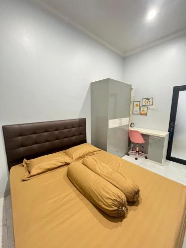 a bedroom with a bed with a large yellow blanket on it at Nameera house in Makassar