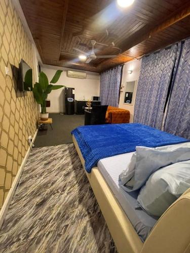 a bedroom with a large bed with a blue blanket at Arrabella Masaki in Dar es Salaam