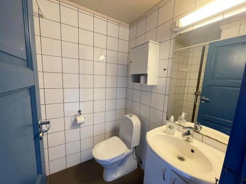 a white bathroom with a toilet and a sink at Nautnes Costal Heaven in Nautnes