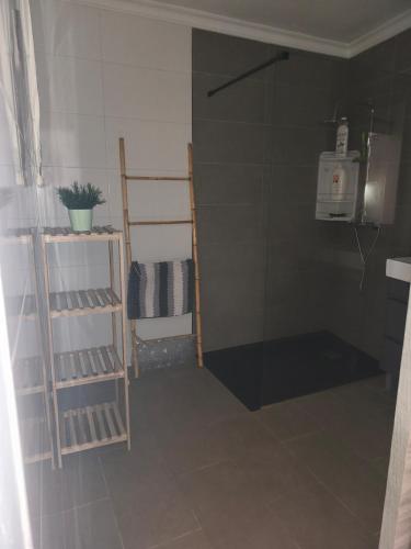 a small bathroom with a shower and shelves in it at Casa la parra in Ardales