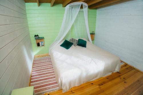 a bedroom with a white bed with a mosquito net at Värska kämping in Värska