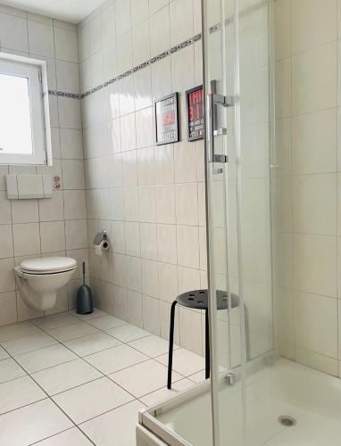 a bathroom with a shower with a toilet and a stool at LohainsLodge in Burbach