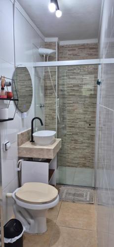 a bathroom with a toilet and a sink and a shower at Cantinho do Sol e Mar in São Vicente