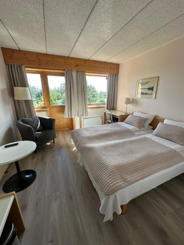 a large bedroom with a large bed and a chair at Toten Hotel Sillongen in Eklund