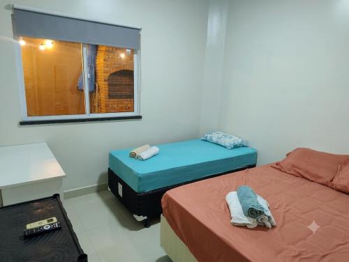 a room with two twin beds and a window at CASA MARIANNA em Paracuru - Piscina, 3 quartos, ar condicionado e perto de tudo! in Paracuru