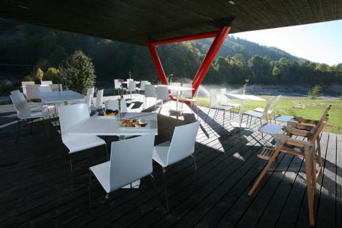 a group of white tables and chairs on a deck at Pensiunea Atra Doftana in Teşila