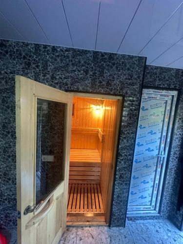 a wooden walkway leading to a sauna in a building at Rezo's Ranch Cottage in Samtredia