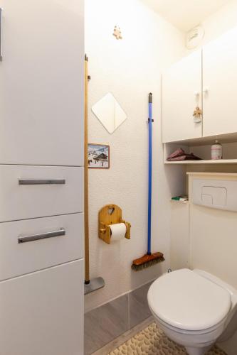 a bathroom with a white toilet and a toilet paper dispenser at Appartement T2 Chalets Superd in Le Dévoluy