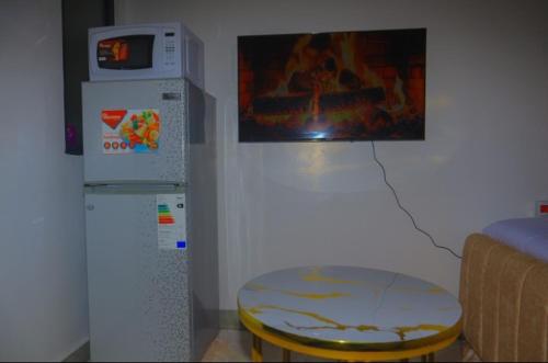 a kitchen with a refrigerator and a table in a room at Eden Homes in Nairobi
