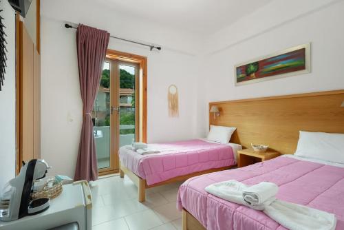 a room with two beds and a tv in it at Dionysus House Lasithi Plateau in Magoulás