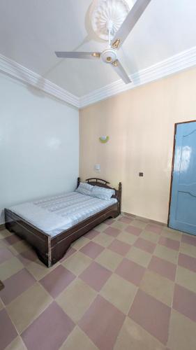 a bedroom with a bed and a ceiling fan at Hôtel St Jo in Bohicon