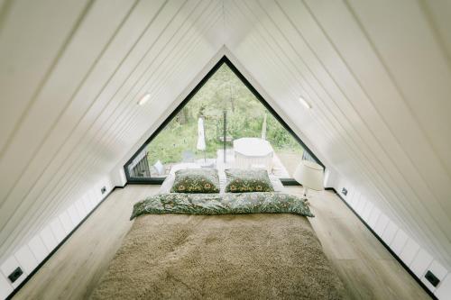 a attic bedroom with a bed and a large window at Majakavahi in Sääre