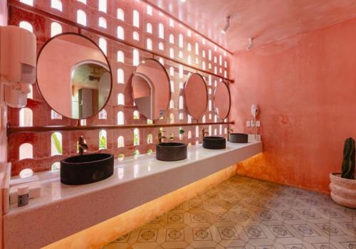 a bathroom with three sinks with mirrors on the wall at Casa Amate 61 - Mérida centro in Mérida