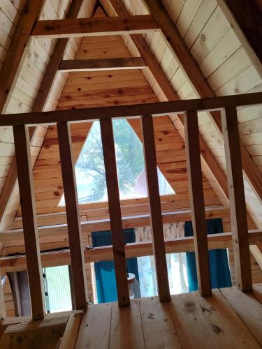 a view from the loft of a wooden cabin with a window at Vikendica Hećo in Višegrad