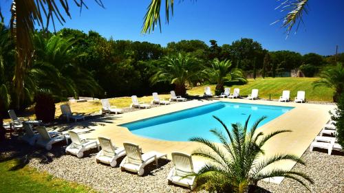 a swimming pool with chaises and lounge chairs around it at Domaine Saint Ferreol in Nizas