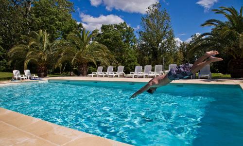 a man is jumping into a swimming pool at Domaine Saint Ferreol in Nizas