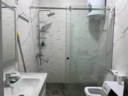 a bathroom with a sink and a glass shower at Atlantis Resort Коттеджи-таунхаузы in Chon-Sary-Oy