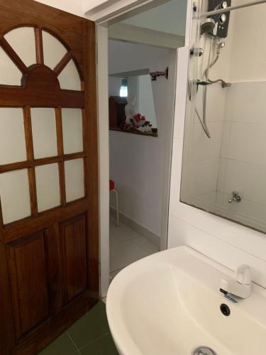 a bathroom with a sink and a mirror and a door at Emerald canopy retreat in Kandy