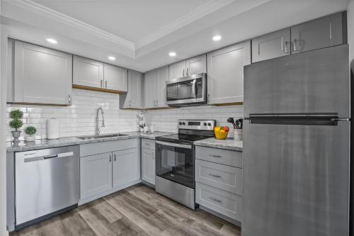 a kitchen with white cabinets and stainless steel appliances at Napili Ridge K6 in Napili-Honokowai
