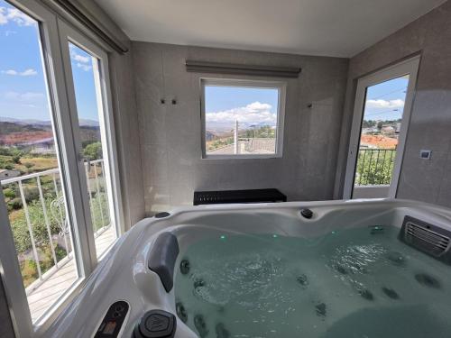 a bath tub in a bathroom with windows at Caia House in Ourondo
