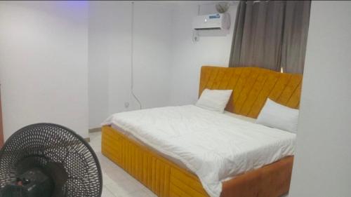 a small bedroom with a bed and a fan at Monarch Appartement in Oshogbo
