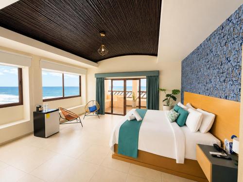 a bedroom with a bed and a view of the ocean at Hotel Los Farallones in La Libertad