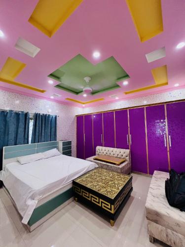 a bedroom with a bed and a purple ceiling at umer cottage in Murree