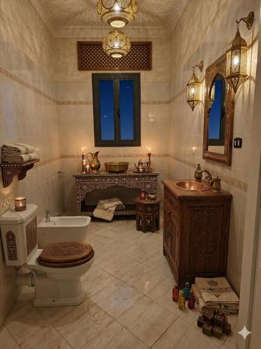 a large bathroom with a toilet and a sink at Villa El Houda in Souk el Had du Drâa