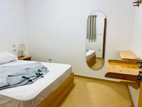 a bedroom with a bed and a mirror at Rafiki Hostels - Dahab in Dahab