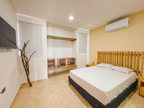 a bedroom with a bed and a television in it at El Viento Beach Apartamentos in San Bernardo del Viento